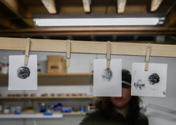 High school interns wait patiently for their wood engraving prints to dry.