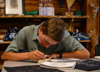 High school intern Clint Wright begins planning his final wood engraving.